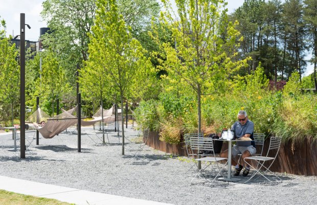 image of students using a table near trees at the EcoCommons